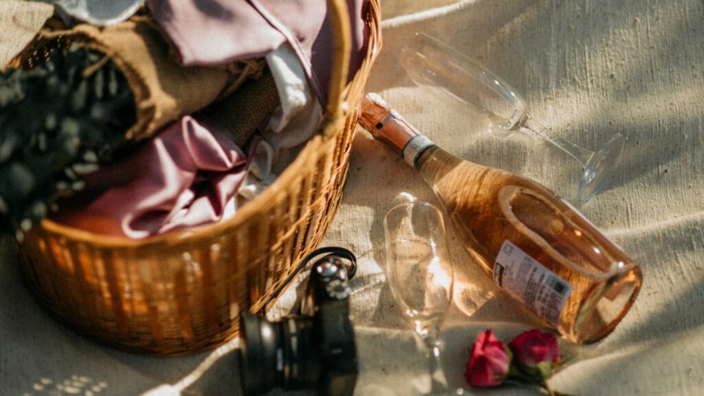 Picnic basket with rose wine and glasses